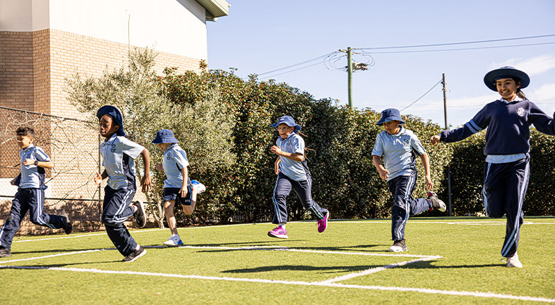 Holy Trinity Catholic Primary School Granville students running on lawn