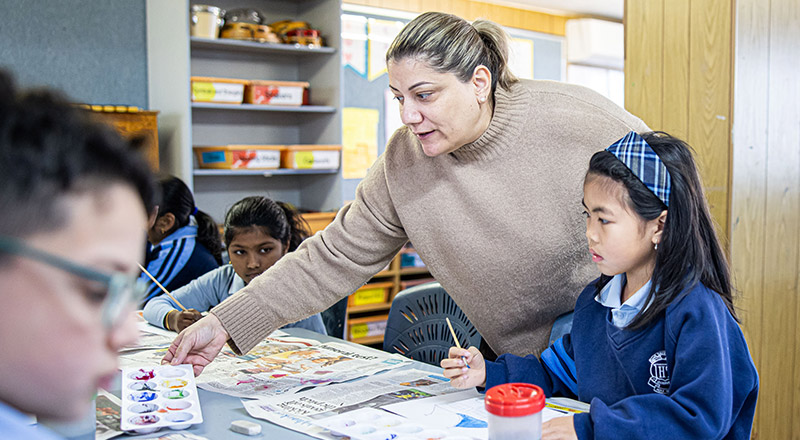 Teacher helping students at Holy Trinity Primary Granville