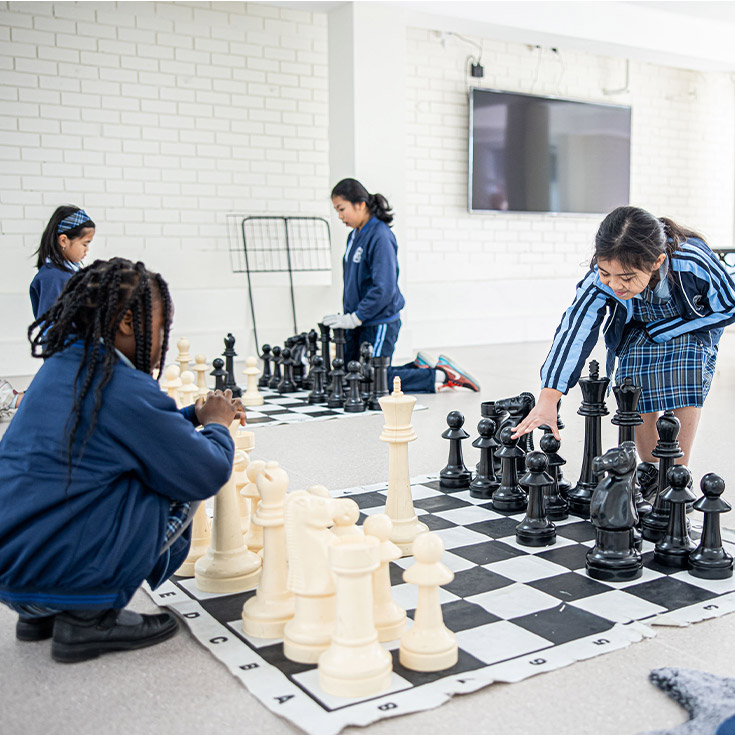 Holy Trinity Catholic Primary School Granville student playing chess on giant board